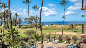 Di pantai, pasir putih, kursi berjemur, dan payung pantai
