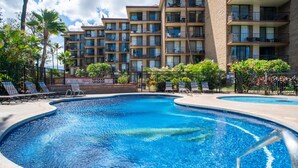 Un hôtel doté d’une piscine, de plusieurs balcons et de palmiers.