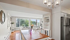 Une cuisine moderne dotée d’un grand îlot central, de meubles blancs et d’un réfrigérateur en acier inoxydable.