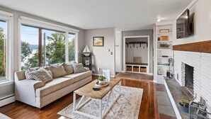 Un salon moderne avec un canapé, une table basse et une cheminée.