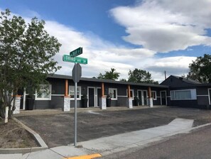 Un motel con una fila di camere, un parcheggio e un cartello stradale per Third Ave SW.
