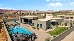 A modern building with a swimming pool, a tennis court, and a view of mountains. - Exclusive Pool Villa (St. George)