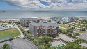 Una zona residencial costera con edificios de varios pisos, una playa y un cielo despejado.