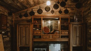 Una cocina rústica con armarios de madera, un colgador para ollas y un refrigerador.