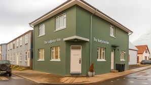 A two-story building with a green facade and white trim, labeled "The Isafjörður Inn." - The Ísafjörður Inn  (Isafjordur)