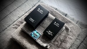 Two black boxes labeled "Sleeping Set" and "Vanity Kit" on a textured gray towel. - The Ísafjörður Inn  (Isafjordur)