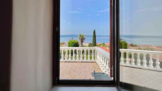 Ein Balkon mit Blick auf das Meer und einen klaren Himmel.