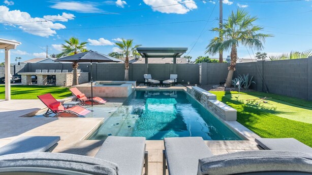 A swimming pool with lounge chairs and a covered seating area. - PuttPutt, Outdoor TVs & BBQ Bar, Pool & Spa! 5 mins from Old Town! (Scottsdale)