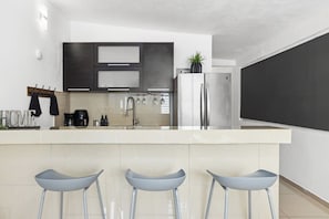 A modern kitchen with a central island, stainless steel appliances, and a minimalist design.