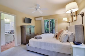 A bedroom with a bed, bedside lamps, a ceiling fan, a TV, and a window with shutters. - Wooded Lakeside adventure, walk to dock, 4 kid kayaks, screened porch, ping pong (Pocono Lake)