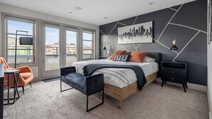 Un dormitorio moderno con una cama grande, un escritorio y una silla.