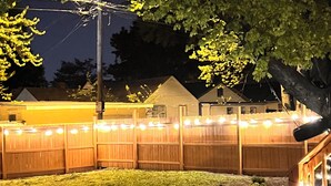 A backyard with a wooden fence, a stone pathway, and a wooden deck. - Near Airport & Major Attractions, 5Mi Downtown, Comfy Loft (Louisville)