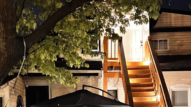 A staircase leading to a second floor, a covered outdoor seating area with chairs and tables, and a brick wall. - Near Airport & Major Attractions, 5Mi Downtown, Comfy Loft (Louisville)