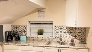 A kitchen with white cabinets, a granite countertop, a sink, a coffee maker, and a toaster. - Near Airport & Major Attractions, 5Mi Downtown, Comfy Loft (Louisville)