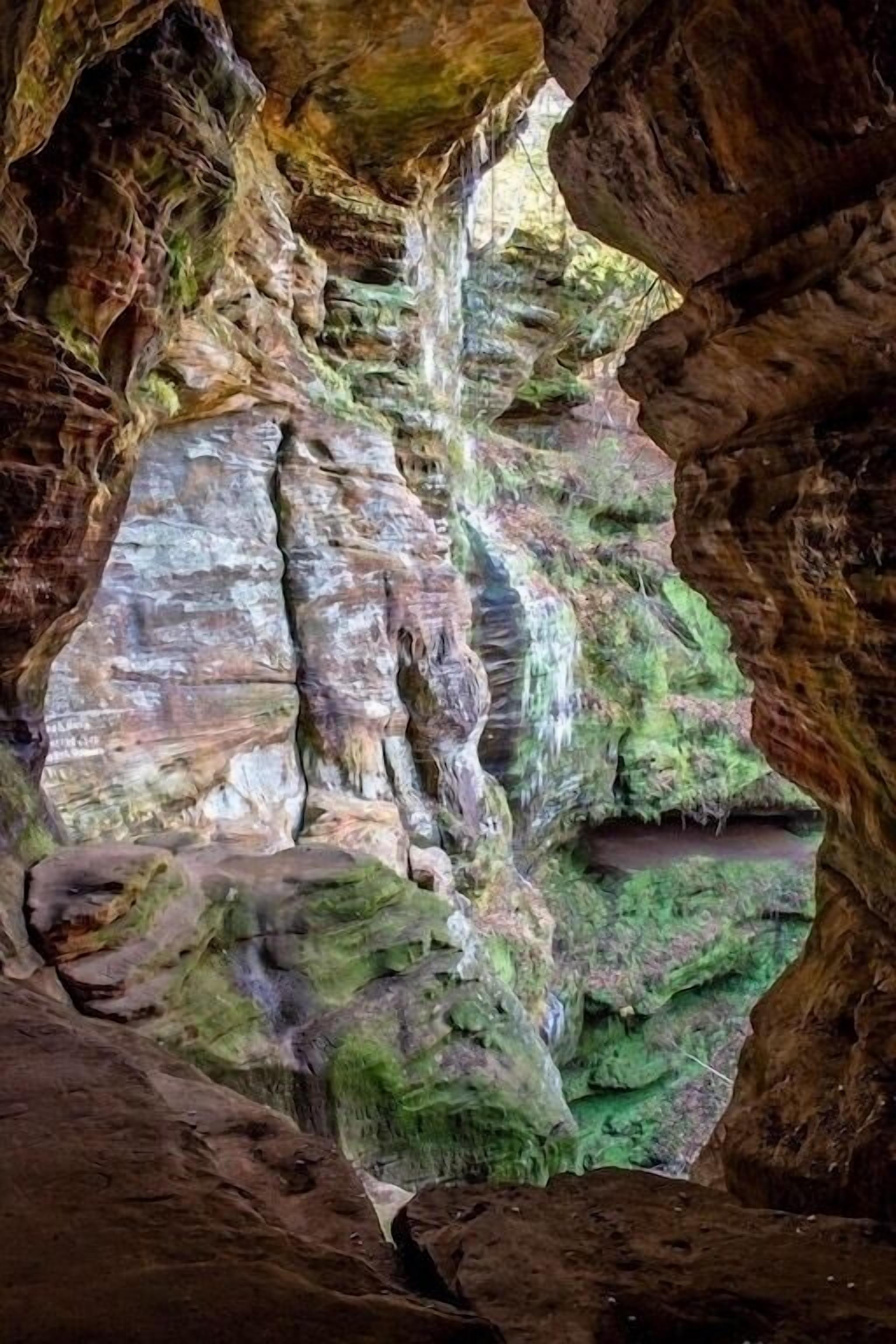 A cave with natural rock formations and a small stream.