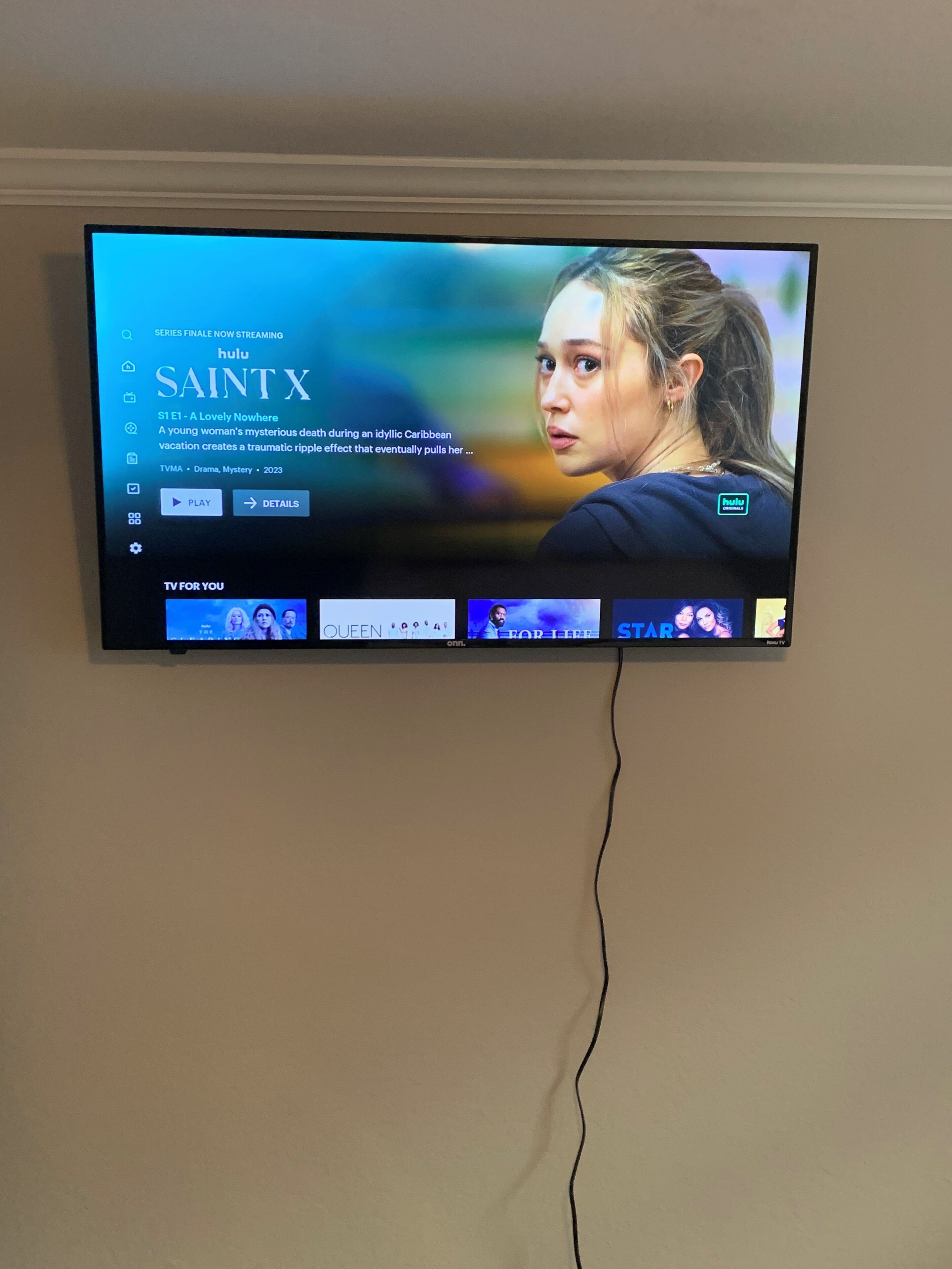 A television displaying a streaming service interface with a series titled "SAINT X" and a synopsis.