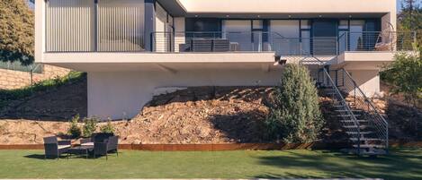 Une maison moderne à deux étages avec une piscine à l’avant.