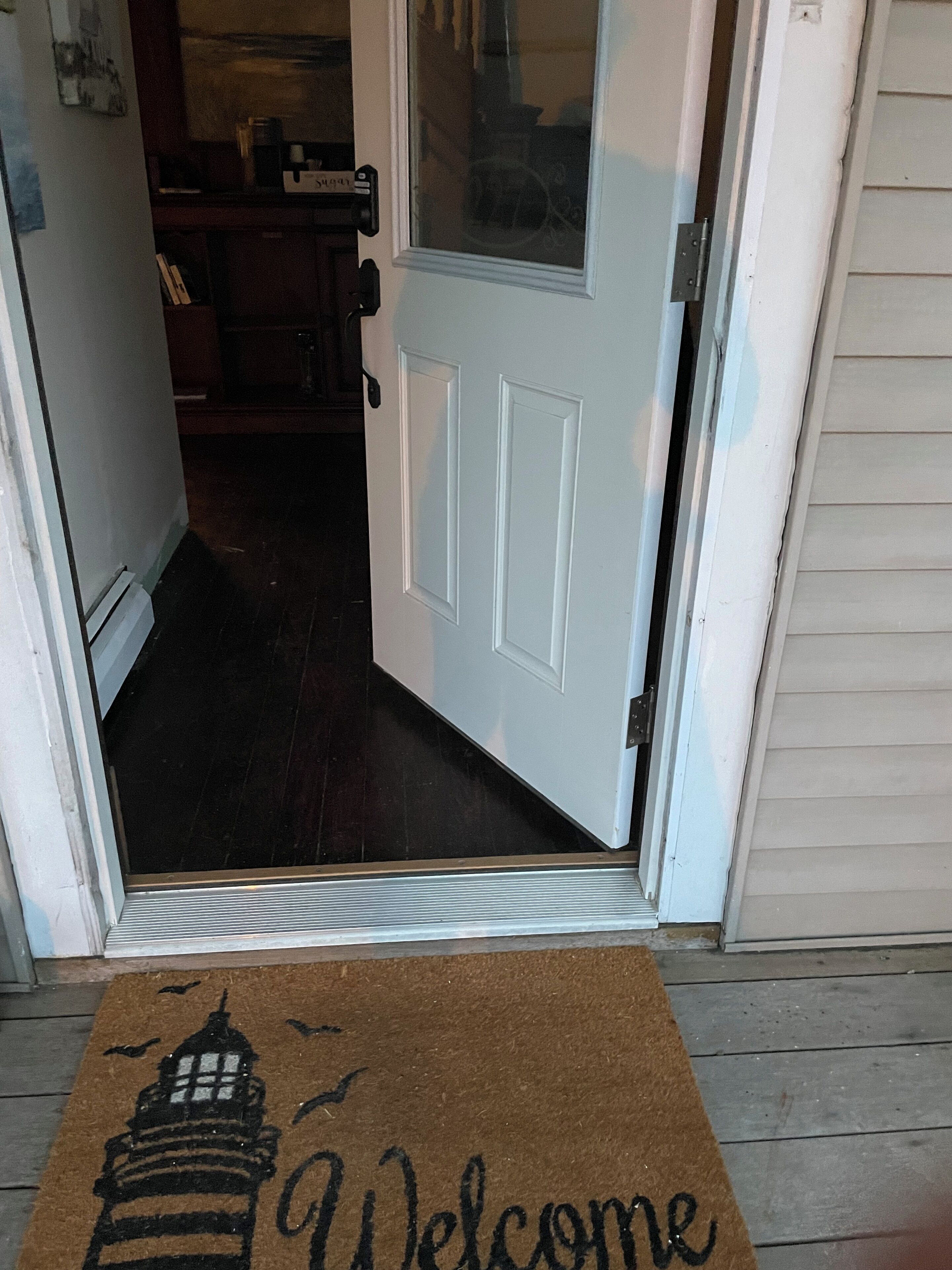 A door with a welcome mat featuring a lighthouse design.