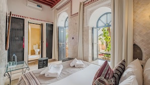 Un dormitorio elegante con una cama grande, una mesita de vidrio y vistas al exterior.