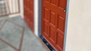 Eine rote Tür mit Fensterglas und Metallbeschlägen.