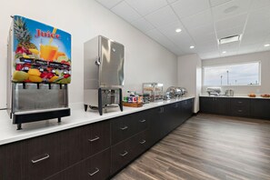A modern kitchen with a juice dispenser, a coffee machine, and a refrigerator. - Holiday Inn Express Kansas City North Parkville (Parkville)