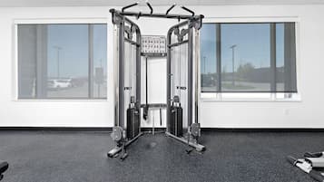 A gym with a squat rack, weight benches, and a pull-up bar.