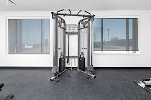 A gym with a squat rack, weight benches, and a pull-up bar. - Holiday Inn Express Kansas City North Parkville (Parkville)