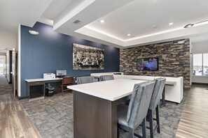 A modern conference room with a large table, chairs, a computer, and a television. - Holiday Inn Express Kansas City North Parkville (Parkville)