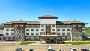A multi-story hotel with a central entrance, parking lot, and a landscaped area. - Holiday Inn Express Kansas City North Parkville (Parkville)