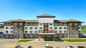 A multi-story hotel with a central entrance, parking lot, and a landscaped area. - Holiday Inn Express Kansas City North Parkville (Parkville)