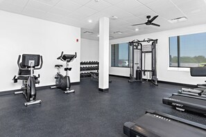 A gym with exercise equipment, a treadmill, and dumbbells. - Holiday Inn Express Kansas City North Parkville (Parkville)