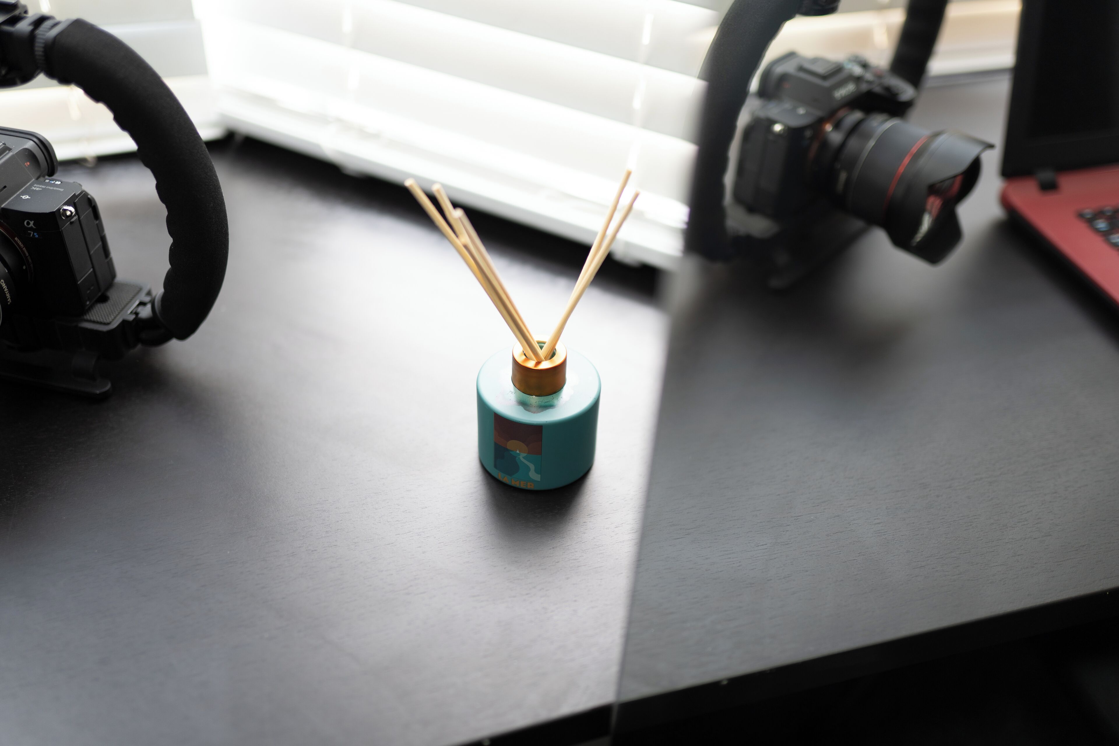 Een bureau met een camera, microfoon en een rietverspreider.