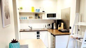 A compact kitchen with white cabinets, a microwave, a kettle, and a coffee maker. - 🔆PINEPLACE🔆BFast,Wi-Fi,Walk2Pizza,Coffee,Liquor (Norlane)