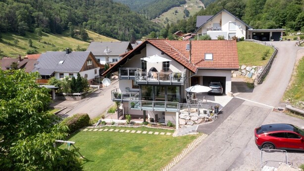 A modern house with a balcony, a garage, and a driveway. - Holiday Apartment "Haus Franziska" with Mountain View, Private Terrace & Wi-Fi (Todtnau /Brandenberg)