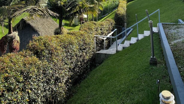 A staircase leading up a grassy slope with a clear blue sky above.