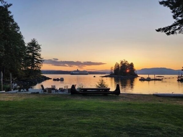 Une vue sur le lac avec un quai, des chaises longues et un bateau.