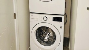 Une machine à laver et un sèche-linge superposés dans une buanderie.