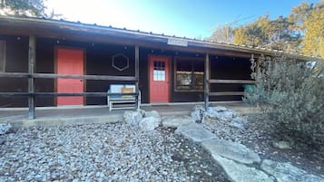A rustic building with a red door and a sign reading "Laredo".