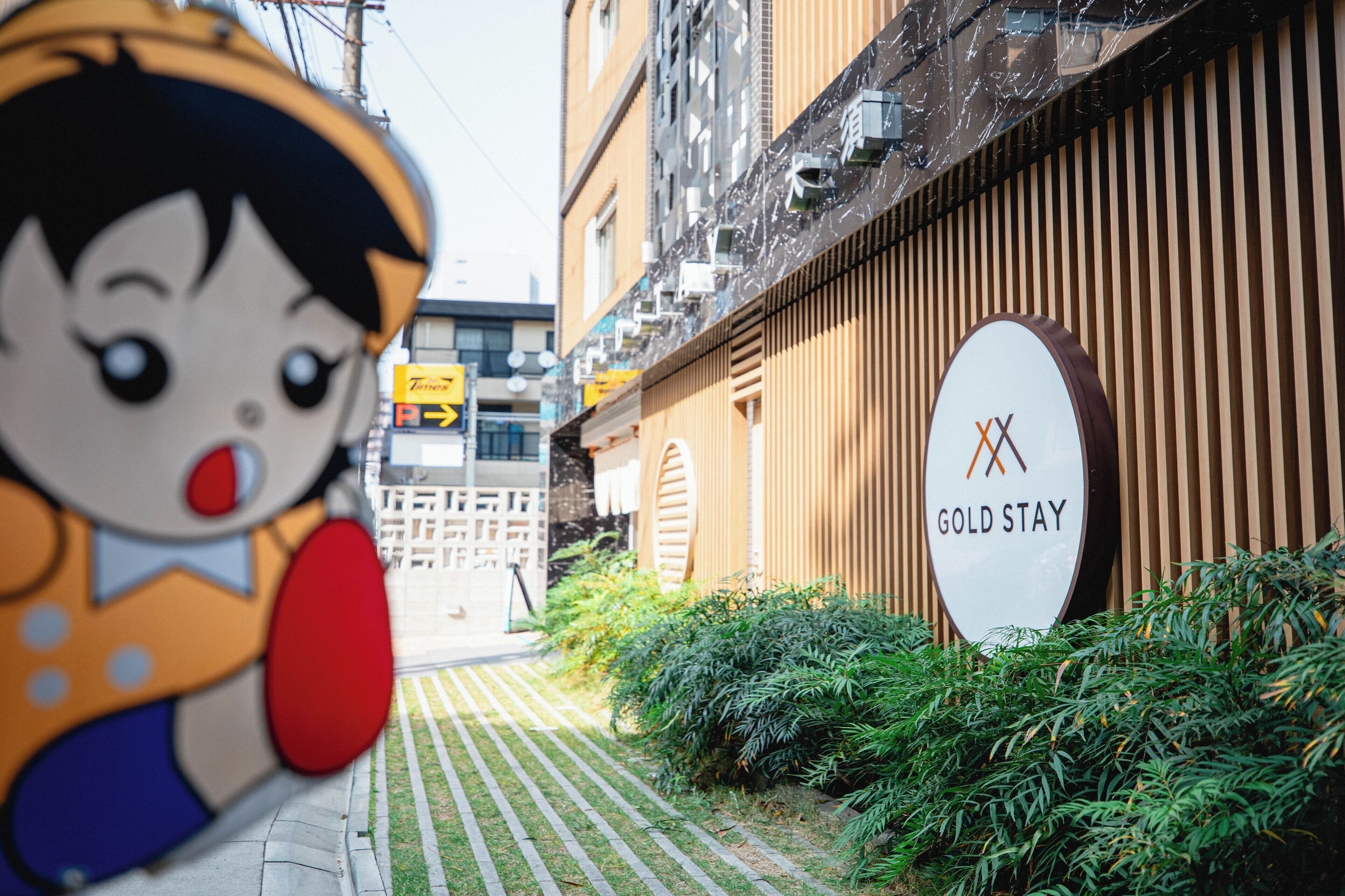 A hotel sign with "GOLD STAY" and a cartoon character.