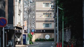 A narrow urban street with a building featuring a sign for "Gold Stay."