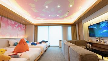 Una habitación de hotel con cama, sofá, televisor y techo decorado con motivos marinos.