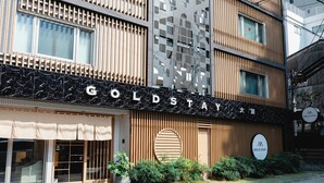 La façade d’un hôtel, avec une enseigne indiquant « GOLDSTAY ».
