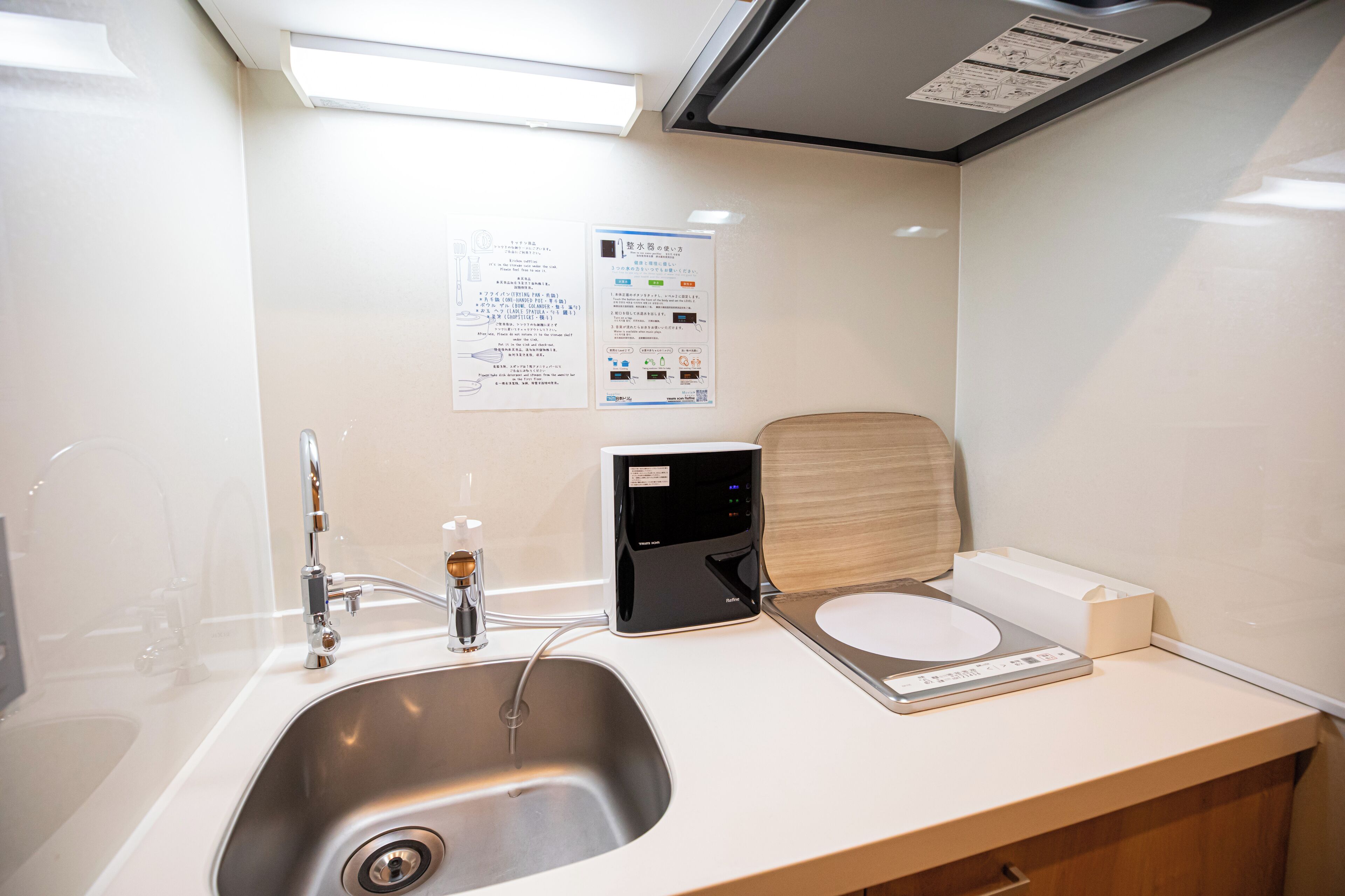 A modern bathroom with a sink, faucet, and a digital scale on the counter.