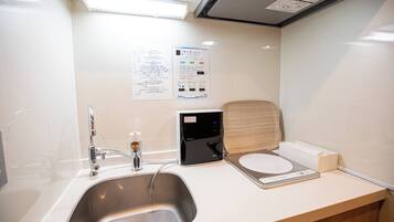 A modern bathroom with a sink, faucet, and a digital scale on the counter.