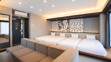 Een moderne hotelkamer met een bank, twee bedden, een decoratieve muur en een groot raam.