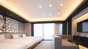 Une chambre d’hôtel moderne dotée d’un grand lit, d’un canapé, d’une télévision à écran plat et d’une grande fenêtre avec des stores.