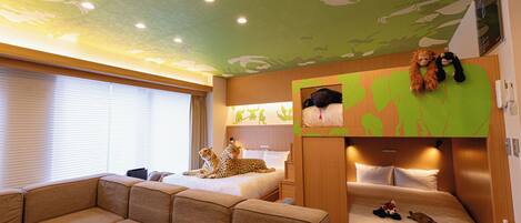 A hotel room with a green ceiling, two beds, a sofa, and a wall-mounted TV.