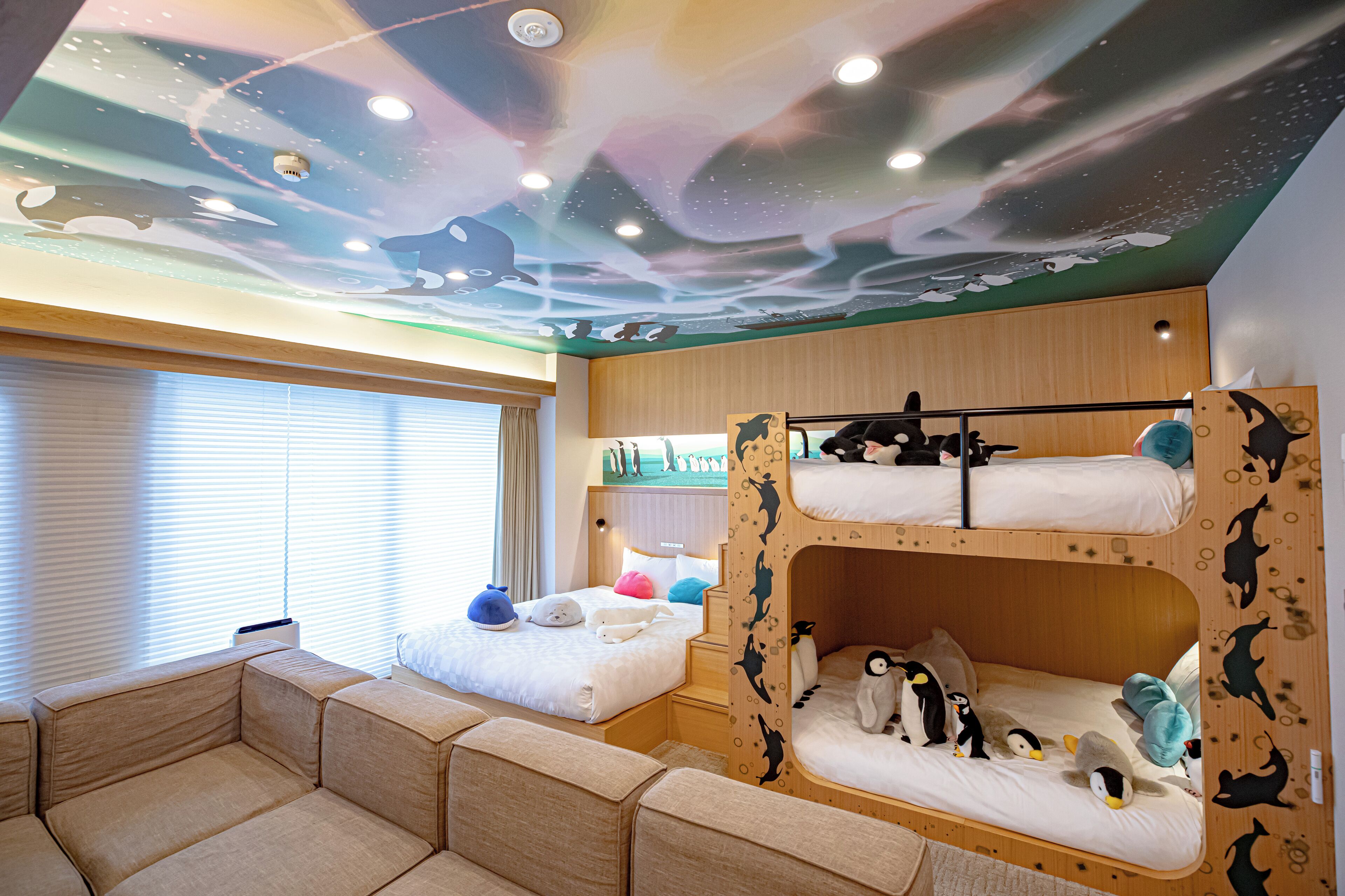 A room with bunk beds, a sofa, and a ceiling mural.