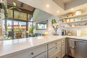 A modern kitchen with a large island, built-in appliances, and a balcony with outdoor seating.