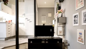 Una sala de estar moderna con un televisor de pantalla plana, un mueble de entretenimiento negro y una alfombra mullida.